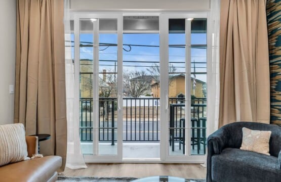 Living room with TV on the wall and a view through the glass door windows.