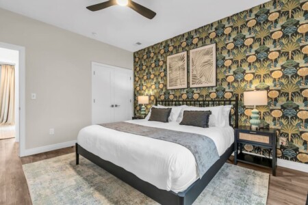 Double bed with side lamp and white closet doors.