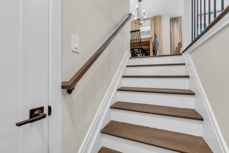 View of staircase ascending with dining table visible at the top.