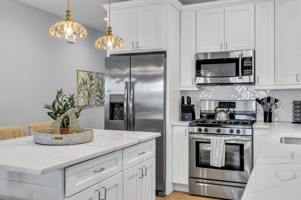 Close-up bright white kitchen featuring a flower vase placed in the middle of the table.