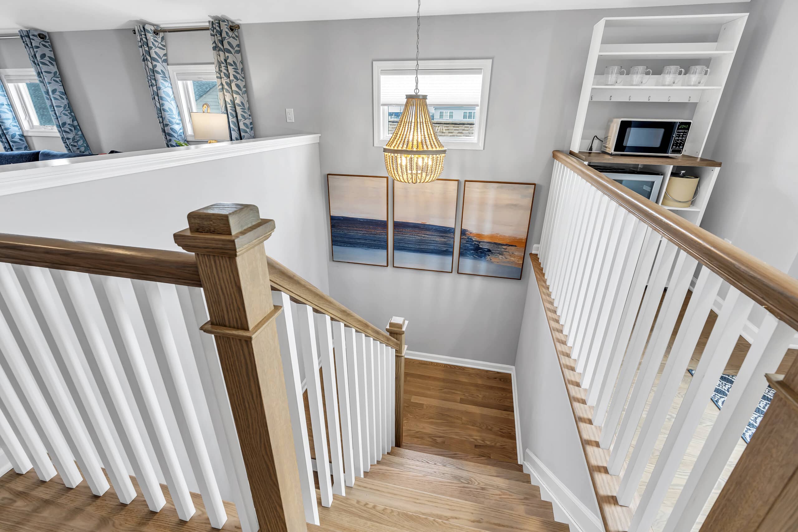 Hallway with three similar framed sea-themed drawings hanging on the wall.