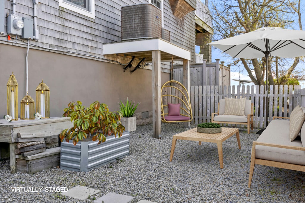 Sunny garden with stone floor, cozy seating, umbrella, and a gold swing with pink pillows.
