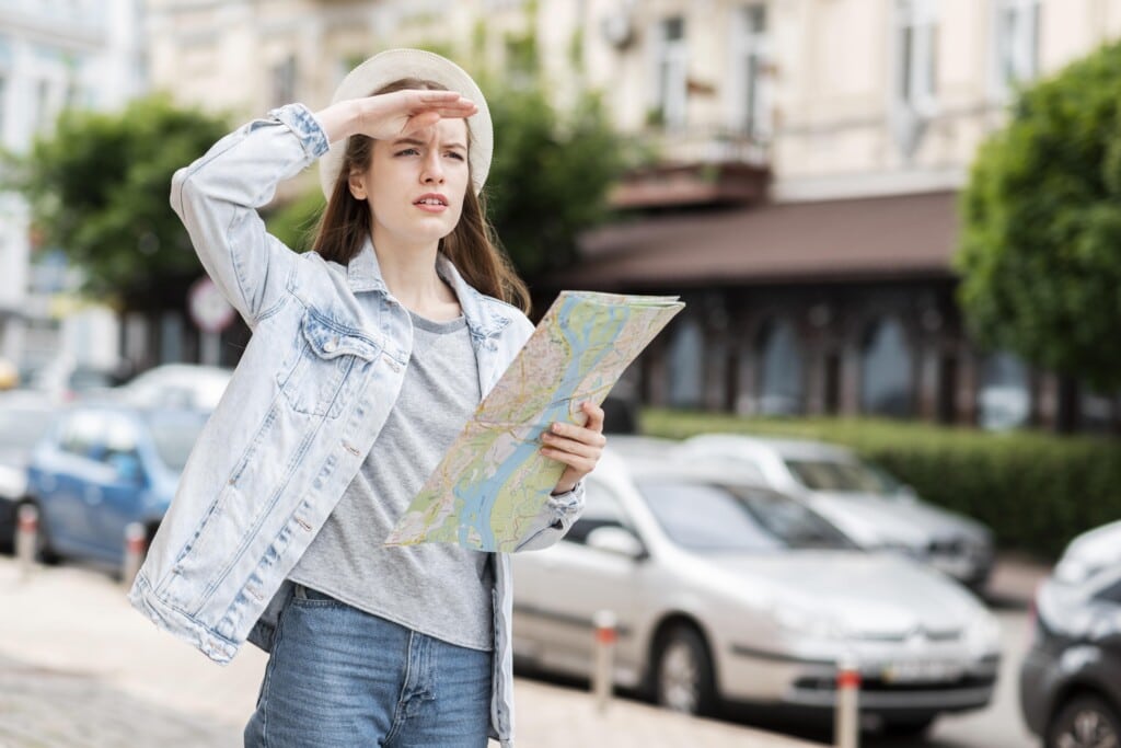 city traveller holding map looking away