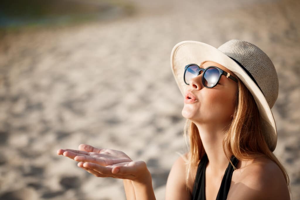 beautiful young cheerful girl wearing glasses hat rests morning beach